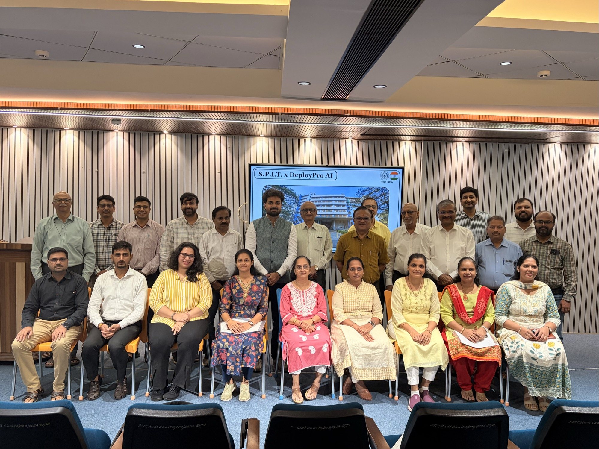 The S.P.I.T. faculty cohort of the July 2026 programme, seated and standing in the auditorium